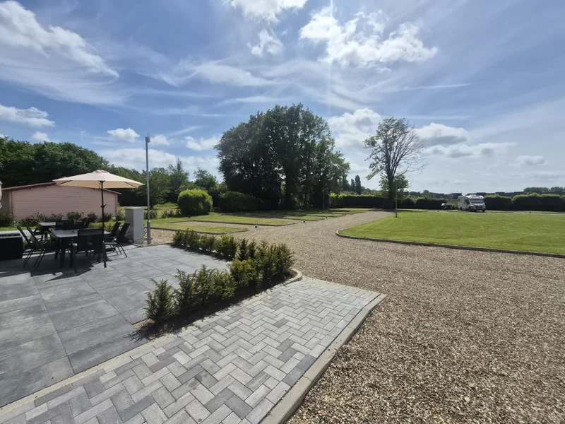 Terras met parasol en uitzicht op het grasveld