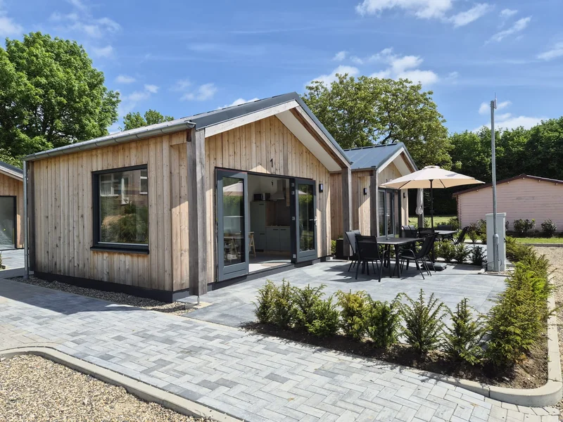Houten vakantiewoning met terras in zomerse sfeer